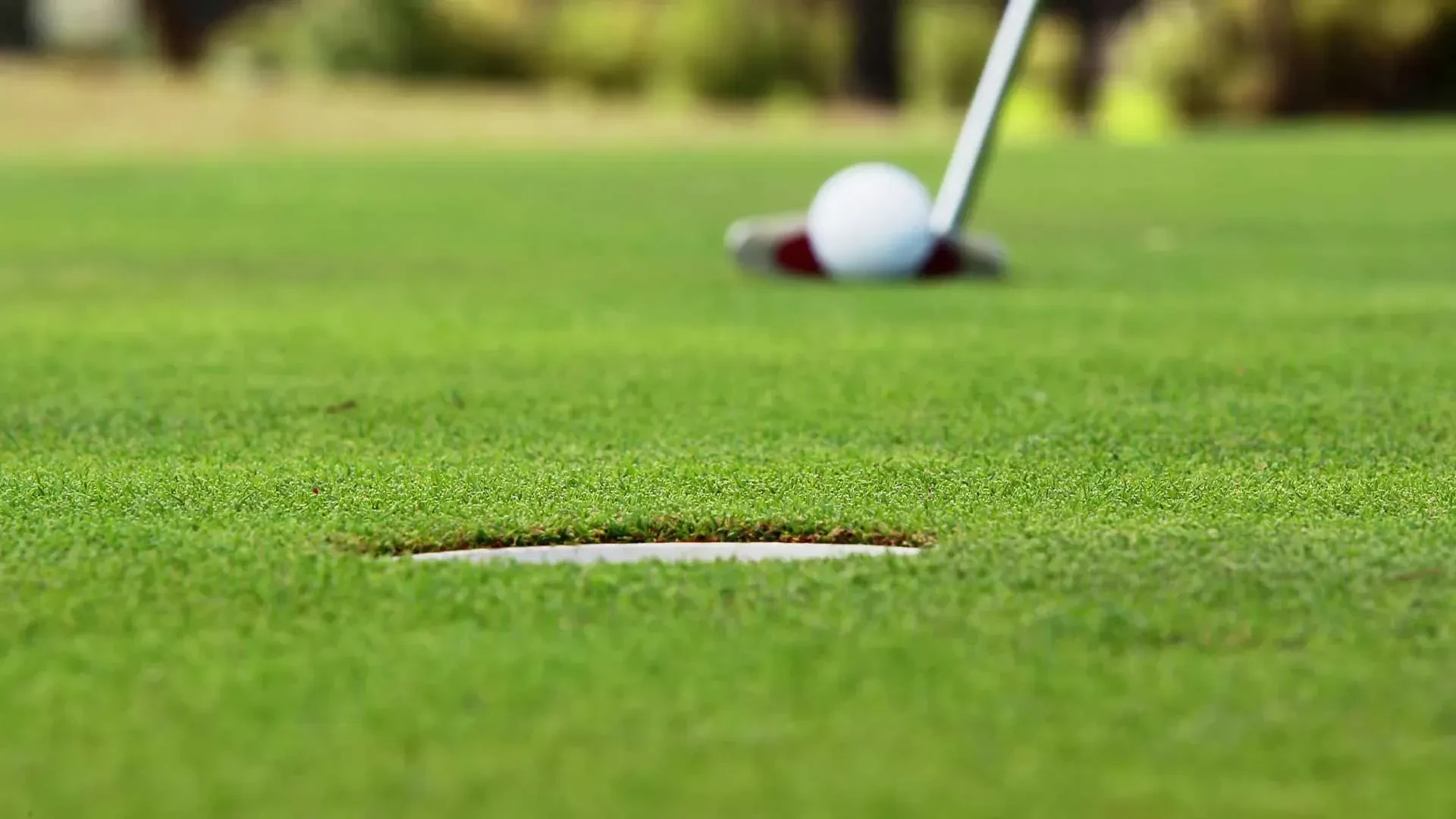 Balle de golf près du trou sur le green.